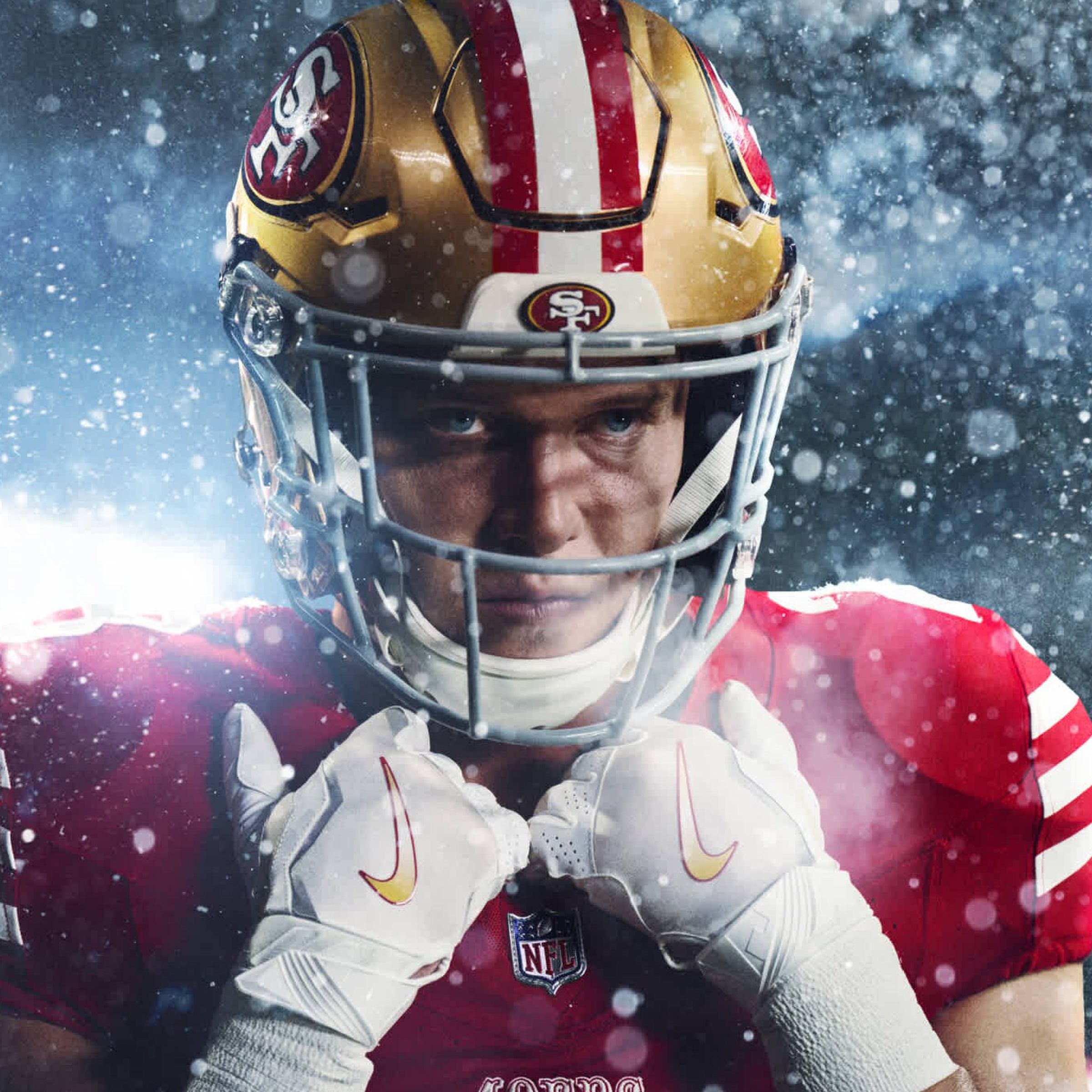 A football player holding his pads, wearing a 49ers uniform.