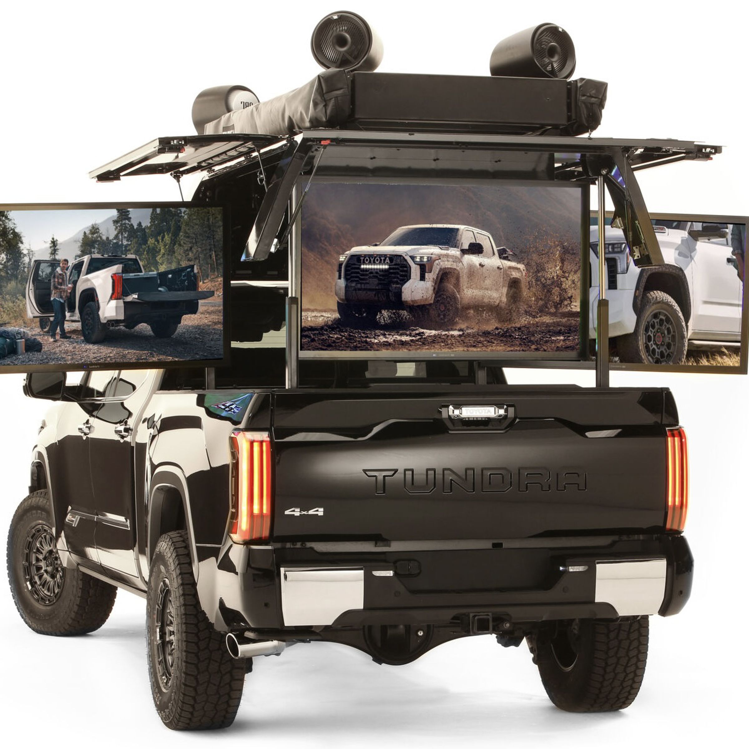 rear of black pickup truck with five TVs fanned out from the bed and a canopy with speakers up top.